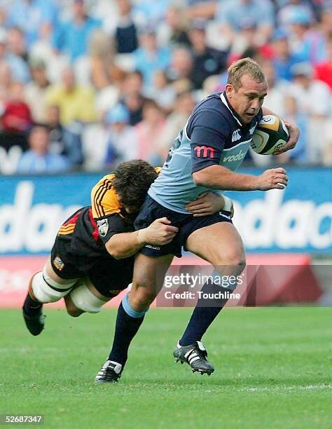 PRETORIA, SOUTH AFRICA -  APRIL 23:  (TOUCHLINE IMAGES ARE AVAILABLE TO CLIENTS IN THE UK, USA AND AUSTRALIA ONLY)   Ettienne Botha of the Bulls is tackled by Steven Bates during the Super 12 match between the Bulls and the Chiefs at the Securicor Loftus Stadium on April 23, 2005 in Pretoria, South Africa.  (Photo by Touchline/Getty Images)