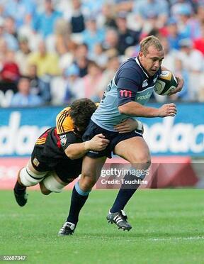 PRETORIA, SOUTH AFRICA -  APRIL 23:  (TOUCHLINE IMAGES ARE AVAILABLE TO CLIENTS IN THE UK, USA AND AUSTRALIA ONLY)   Ettienne Botha of the Bulls is tackled by Steven Bates during the Super 12 match between the Bulls and the Chiefs at the Securicor Loftus Stadium on April 23, 2005 in Pretoria, South Africa.  (Photo by Touchline/Getty Images)